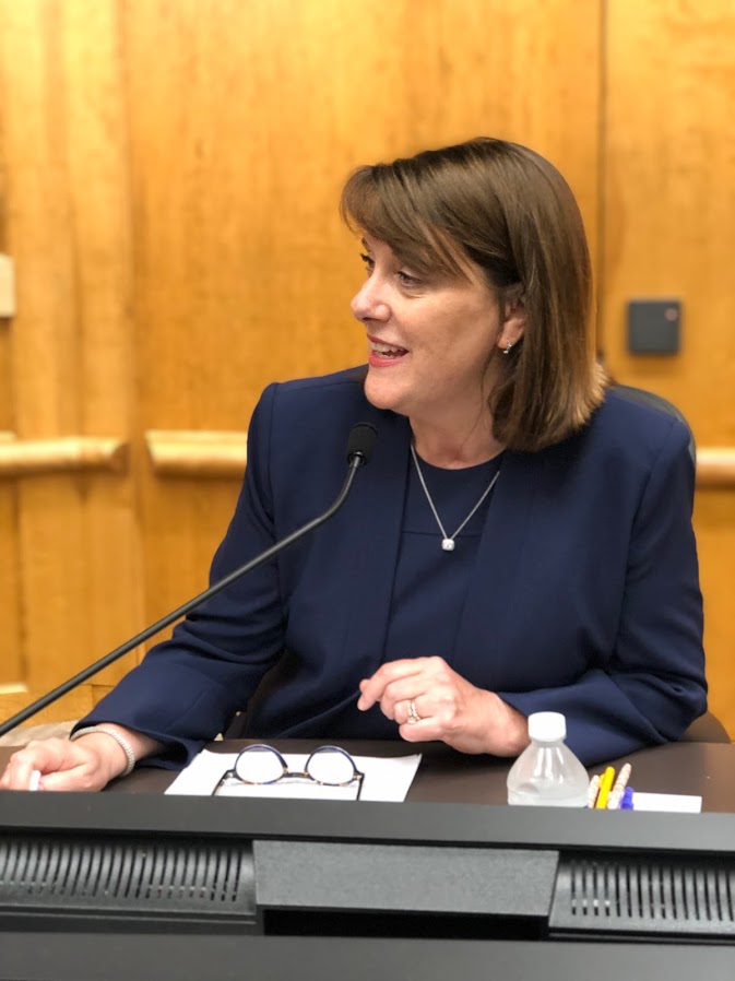 Lisa Toomey sitting in front of a microphone and smiling sideways