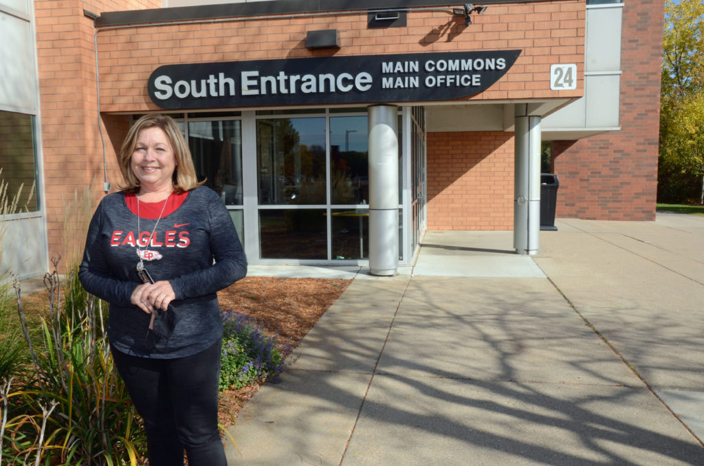 Carolyn Henning, RN smiling in front of the "South Entrance Main Office"