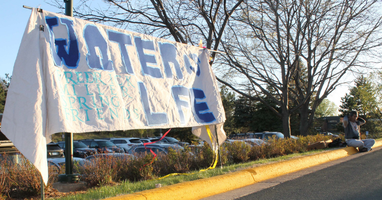 "Water is Life" read the banner as some of Tuesday's May 4, 2021 hearing attendees spilled outside city hall. (Photo by Mark Weber)
