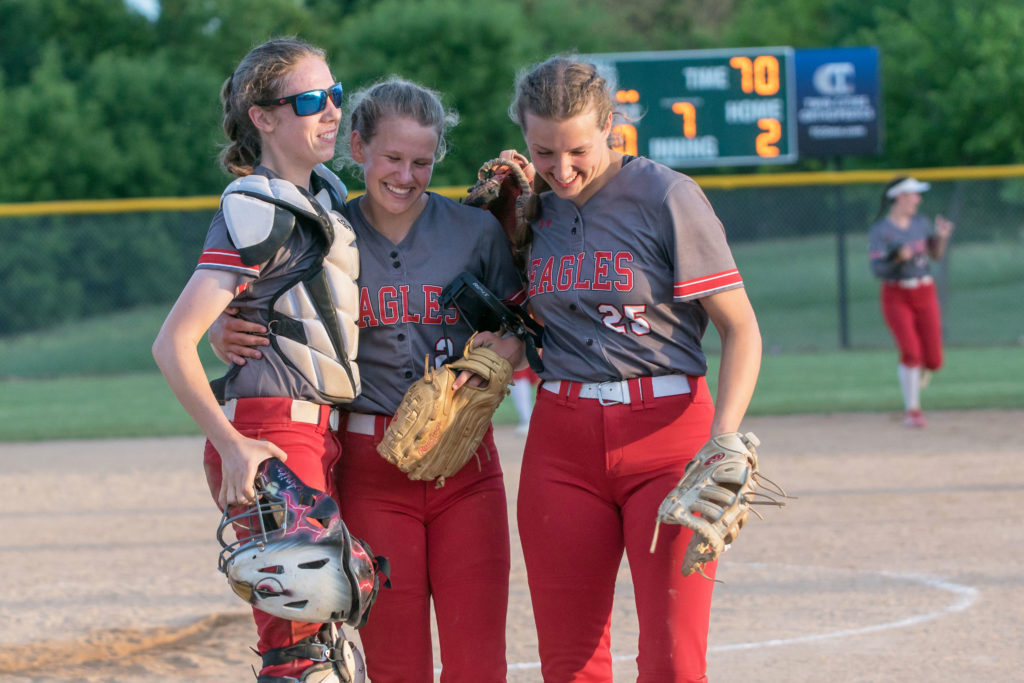 Eagles pitcher, Kari Welter, center, is congratulated by her catcher Anika Lange, left, and her sister Annika after completing a shutout against Minnetonka to advance to thee Section 2AAAA championship June 10.