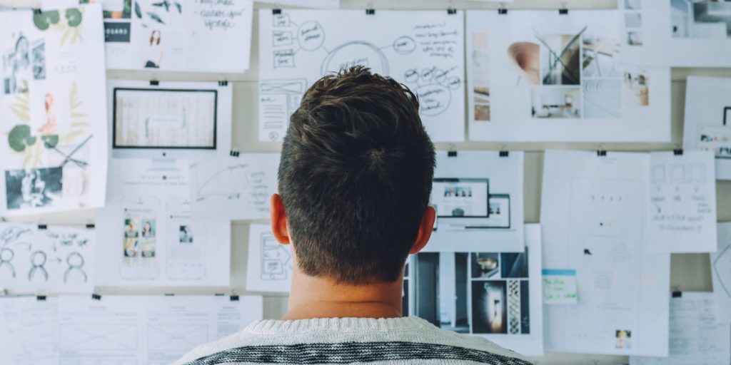 Image of man looking at a bulletin board.