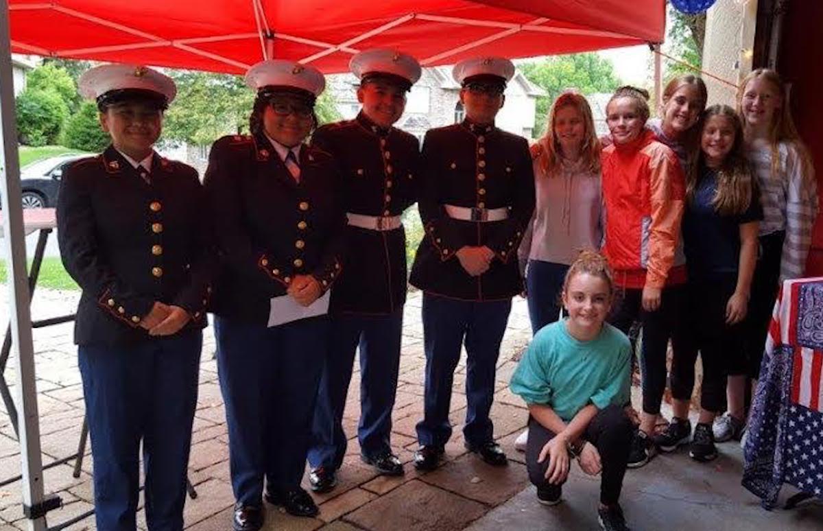 The Como Park High School Marine Corps JROTC program will benefit from proceeds raised during this year's lemonade stand. Students (in uniform) pose with neighborhood kids. Photo courtesy of Sue Donkersgoed 