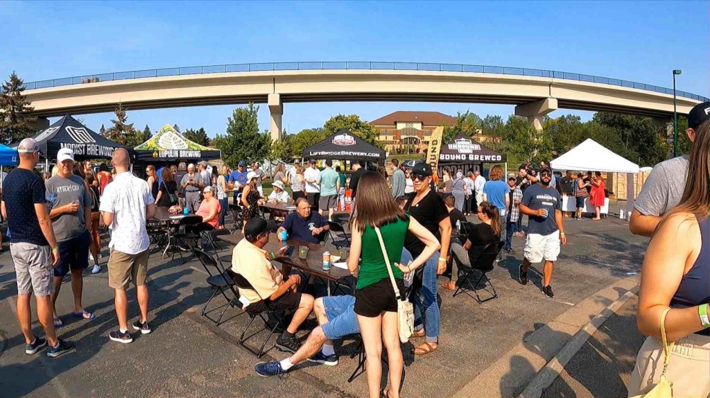 tables, people and LRT bridge at Purgatory Creek Park.