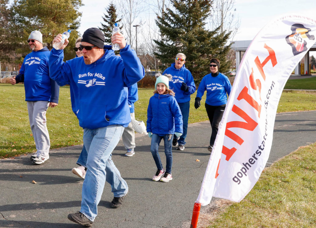 Several runners and walkers cross the finish line during the Mike Elhard Memorial Run on Saturday morning, Nov. 20. Proceeds raised by the event go to Elhard's family. Photo by Gillian Holte