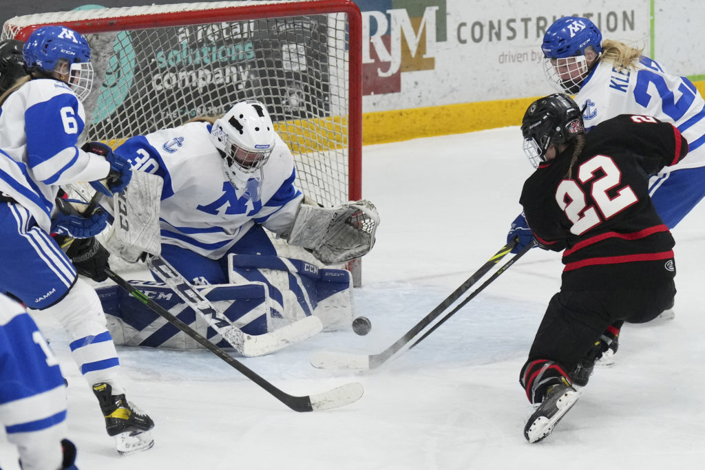 Eden Prairie forward Paige Holt attempts a shot on Minnetonka goalie Sophia Johnson. Minnetonka won 7-0 on Feb. 15. 
Photo by Rick Olson