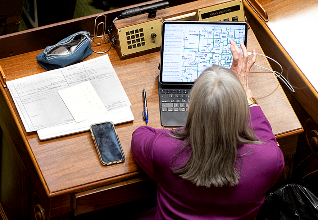 State Rep. Ginny Klevorn studying the new maps at her desk on the Minnesota House floor.
MinnPost photo by Tom Olmscheid