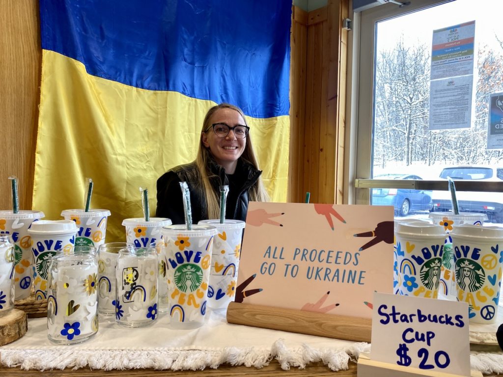 Yana Verkholyak sold Starbucks cups during the "Kids Against War" fundraiser at Camp Eden Wood on Sunday. Now living in Maple Grove, she is originally from Ukraine. Photos by Stuart Sudak