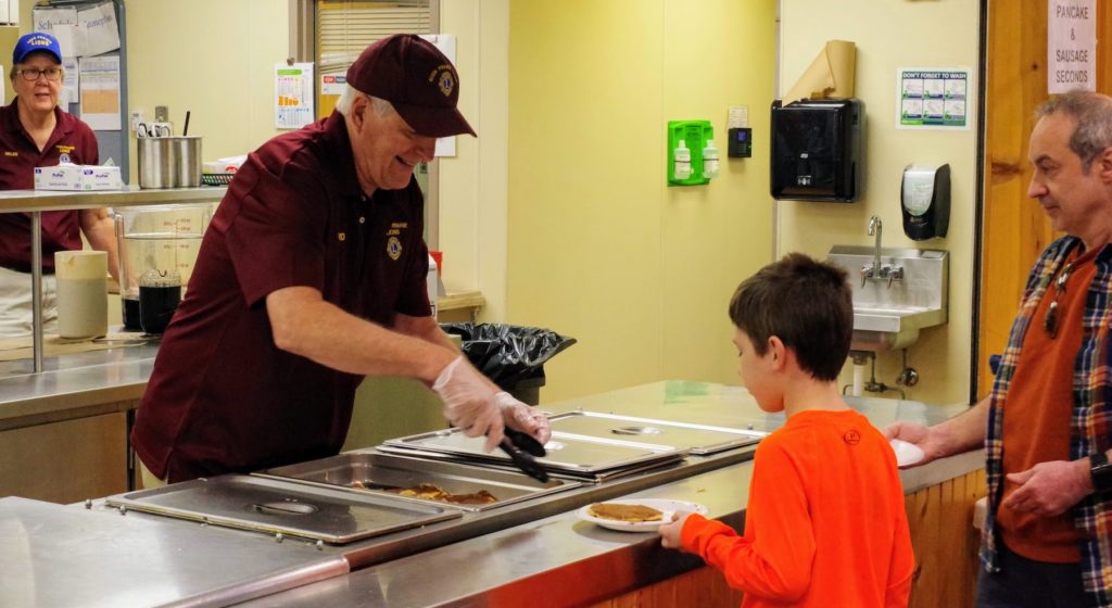 Eden Prairie Lions Club member Richard Klatte serves up breakfast during the club's Pancake Breakfast fundraiser last year. 