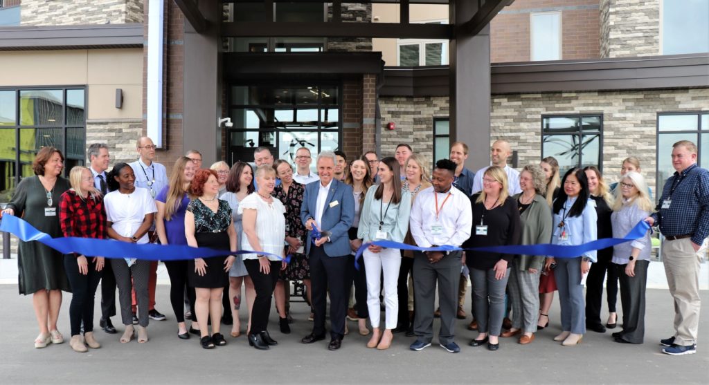 Eden Prairie Mayor Ron Case (center) presided over the ribbon-cutting ceremony officially dedicating Flagstone senior living community on May 5. Joining Case were business and civic leaders associated with the development and employees of Flagstone. Photo courtesy of Presbyterian Homes & Service (PHS)