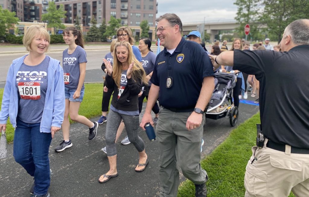 Eden Prairie Police Chief Matt Sackett (right) gives  Detective Carter Staaf a pat on the back while he walks with Kitty Porta (far left) and Margie Williamson in Saturday's Stop the Trafficking 5K at Purgatory Creek Park. Photos by Stuart Sudak
