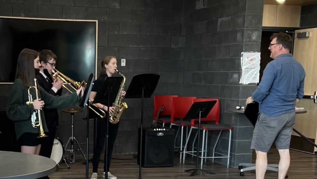 Jazz band members (left to right) Annika Rice, Jasper Moffitt, and Kendall Scott, with Band Director Benjamin Anderson, prepare to entertain arriving event attendees. Photo courtesy of Lynn Scott