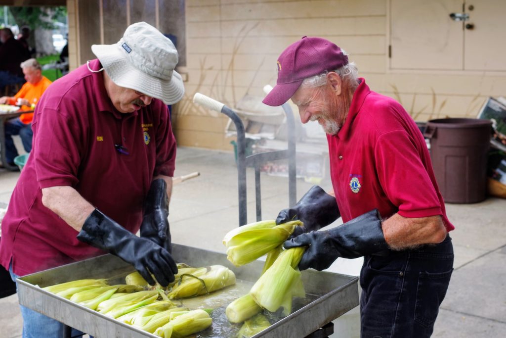 Lions Club members (l-r) Ron Whitman and Tom Anderson prepare the corn for steaming. Photo courtesy of Gary Stevens/Eden Prairie Lions Club
