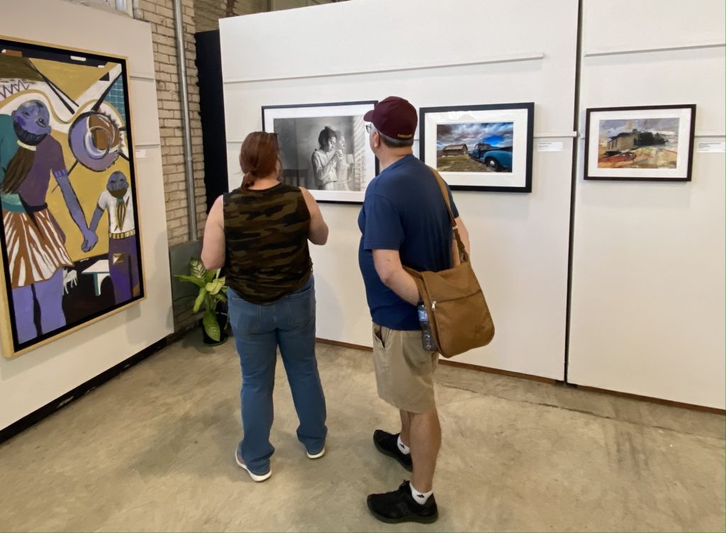 Fairgoers admiring Daniel Volenec’s “Tomorrow," which won a 3rd place ribbon and the Minnesota Artists Association Award.