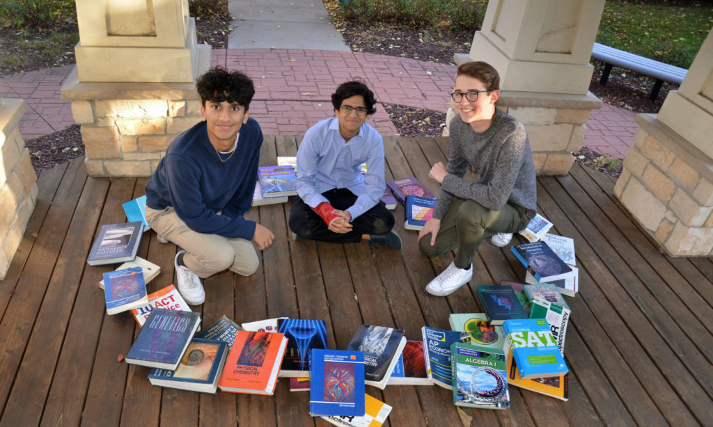 Educaturu founder Mohit Agarwal, center, with volunteer Aadit Bhavsar, left, and board member Lucas Wagner, right, surrounded by some of the donated books they have received. Photos by Jim Bayer
