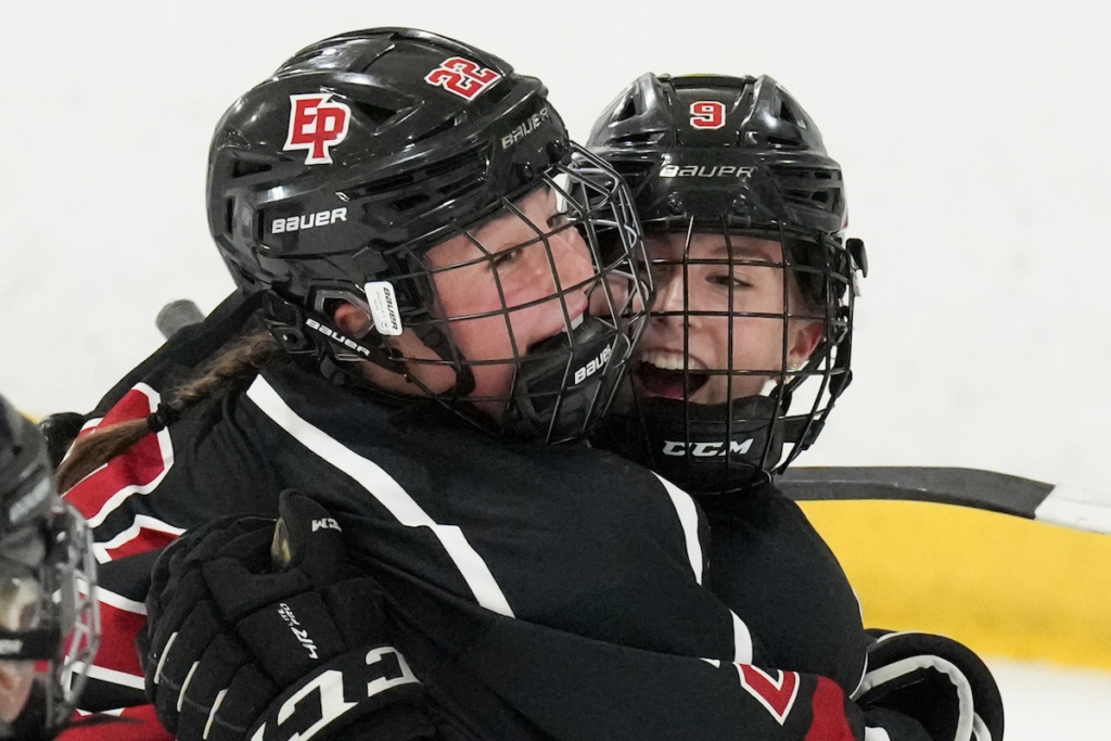 Eagles senior forward Paige Holt (22) and sophomore forward Lauren Pottinger (9) celebrate Pottinger’s 2-0 goal in the first period Tuesday vs. Chaska/Chanhassen. Photo by Rick Olson