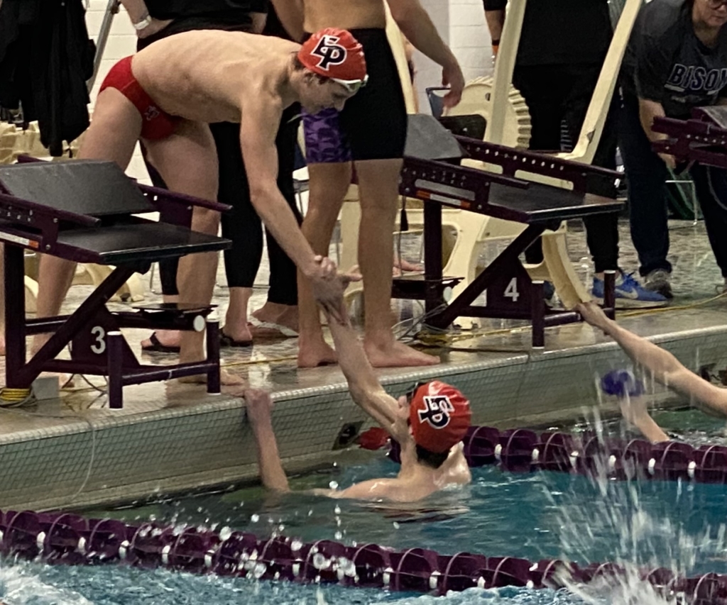Sophomore Drew Ploof congratulated teammate Charlie Folks after they broke the pool record in the varsity 400 relay.