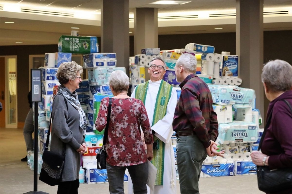 St. Andrew Lutheran Church pastor Peter Johnson talks with church members near a collection of paper goods that will be transformed into a massive fort for display at Empty Bowls 2023. Photo courtesy of St. Andrew Lutheran Church