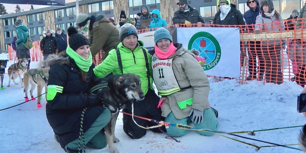 Dr. Heather Hadley of Mission Animal Hospital gathers with Ryan Redington and Sarah Keefer of Redington Mushing, along with Wildfire from the Redington kennel, at the finish line of the 2023 John Beargrease Sled Dog Marathon. Keefer, with Wildfire as part of her dog team, finished third in the 300-mile race that concluded Tuesday, Jan. 31. Photo courtesy of Northern News Now, northernnewsnow.com/beargrease