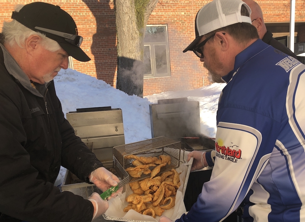 Let's Go Fishing volunteers Dan Voye, left, and Scott Nelson, right, transferred fried fish from the cooker to a pan for feeding those who attended the annual fish fry fundraiser. Photos by Joanna Werch Takes