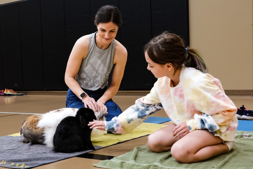 Caitlin Niedzwiecki and her daughter, Emma, petting some of the bunnies before the yoga begins.