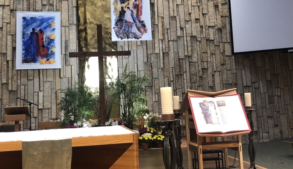 St. John's Bible on display at altar with banners behind altar