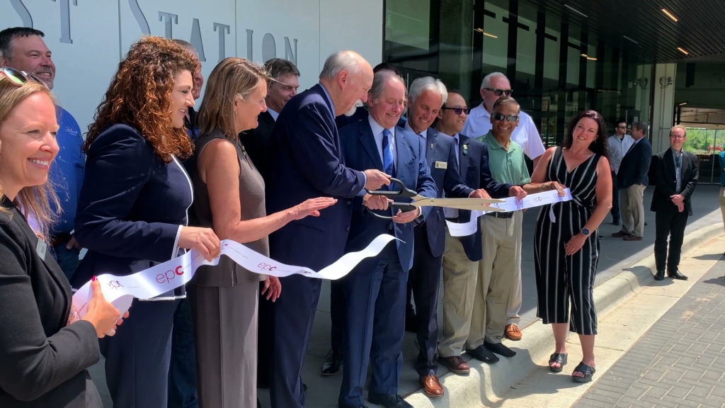 An image of Southwest Transit Commission Chair Jerry McDonald and Met Council Chair Charlie Zelle cut the ceremonial ribbon outside SouthWest Station's new waiting room. Eden Prairie Mayor Ron Case and retired Mayor Nancy Tyra-Lukens stand next to the pair.