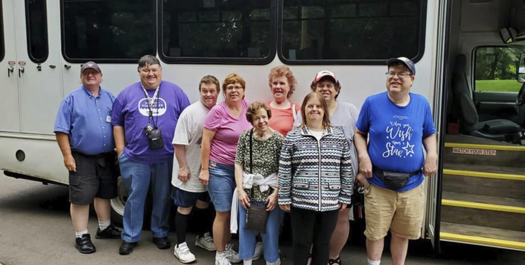 group of developmentally disabled adults standing outside a bus