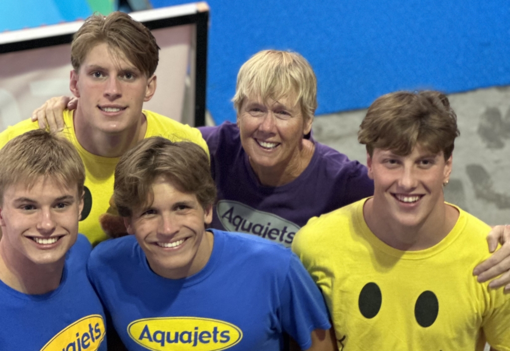 (L-R) Henry Webb, Luke Logue, Drew Ploof, their Aquajets coach Kate Lundsten, and Charlie Egeland. Photo by Emma Kern / Aquajets 