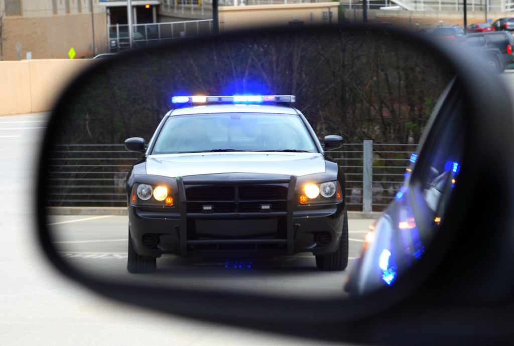 A police car reflected in a vehicle's rearview mirror. In July, Minnesota law enforcement agencies ramped up efforts, issuing over 20,000 speeding tickets, with Eden Prairie setting its own one-month citation record.