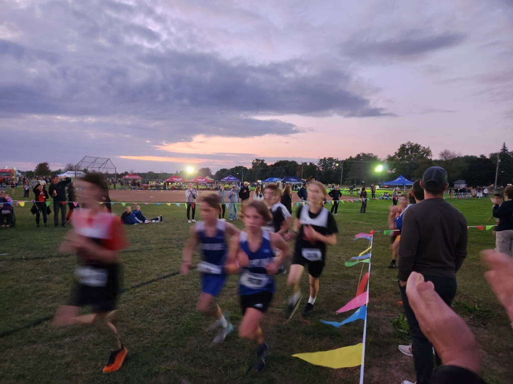 Middle school boys race under the lights at the cross country Metro Invitational.