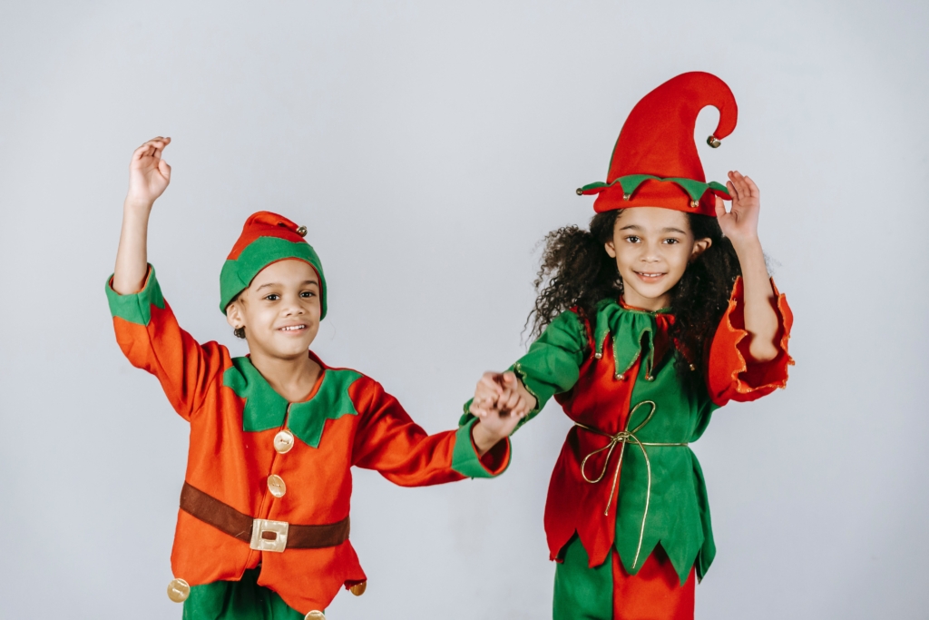 A boy and girl dressed as elves holding hands