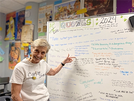 Linda "Wally" Wallenberg stands in front of a white board filled with quotes from her AP Lit students. Photo by Mollee Francisco