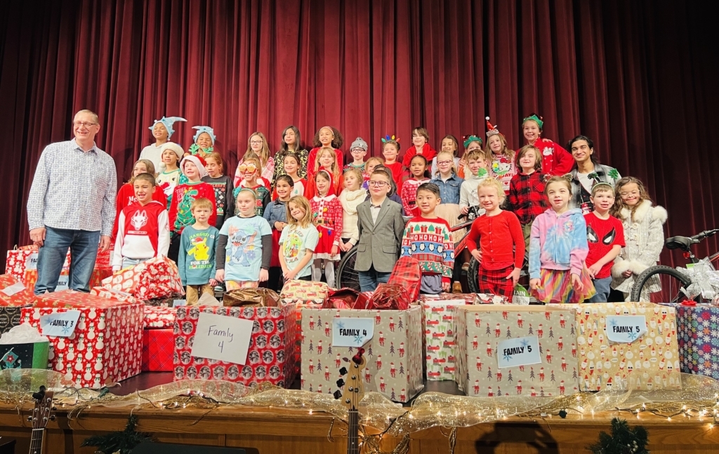 ISM Lower School students with Good in the Hood's Shawn Morrison (far left) and ISM senior Aarya Batchu (far right, center row) and the gifts. Photo by ISM
