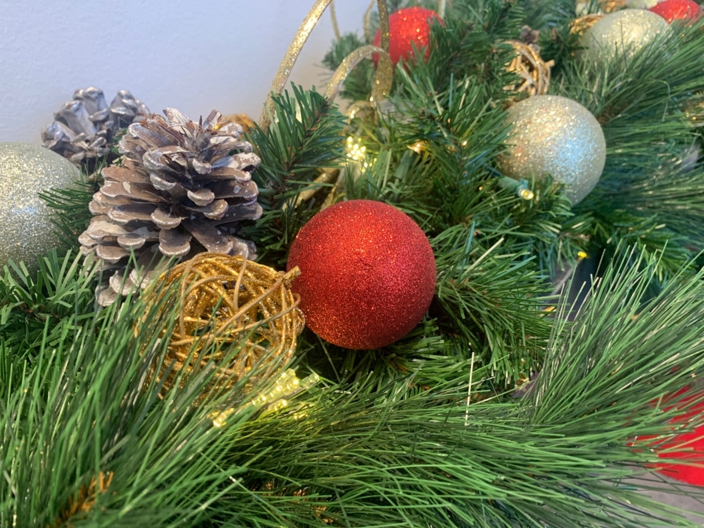Pinecones, and red, gold, and silver balls nestled in evergreen branches.