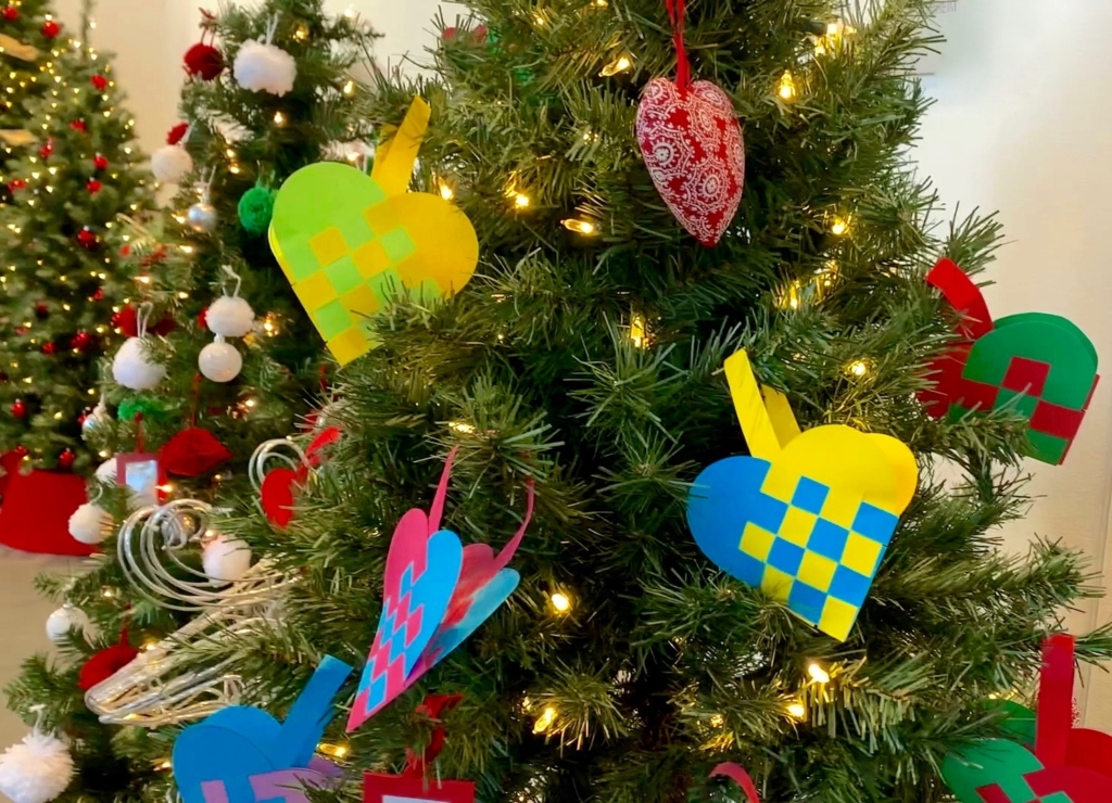 a variety of colorful paper ornaments on a Christmas tree with white lights