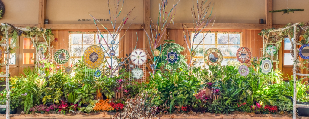 Flowers, mosaic mirrors, fabric wrapped trees indoors in McQuinn Great Hall