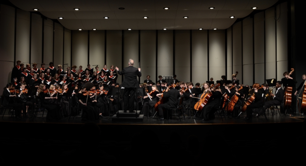 Mike Whipkey directing the Chamber Choir, Concert Orchestra, and Wind Ensemble in their performance of "I Believe" on March 7 at the EPHS Performing Arts Center. Photo by Scott Allen