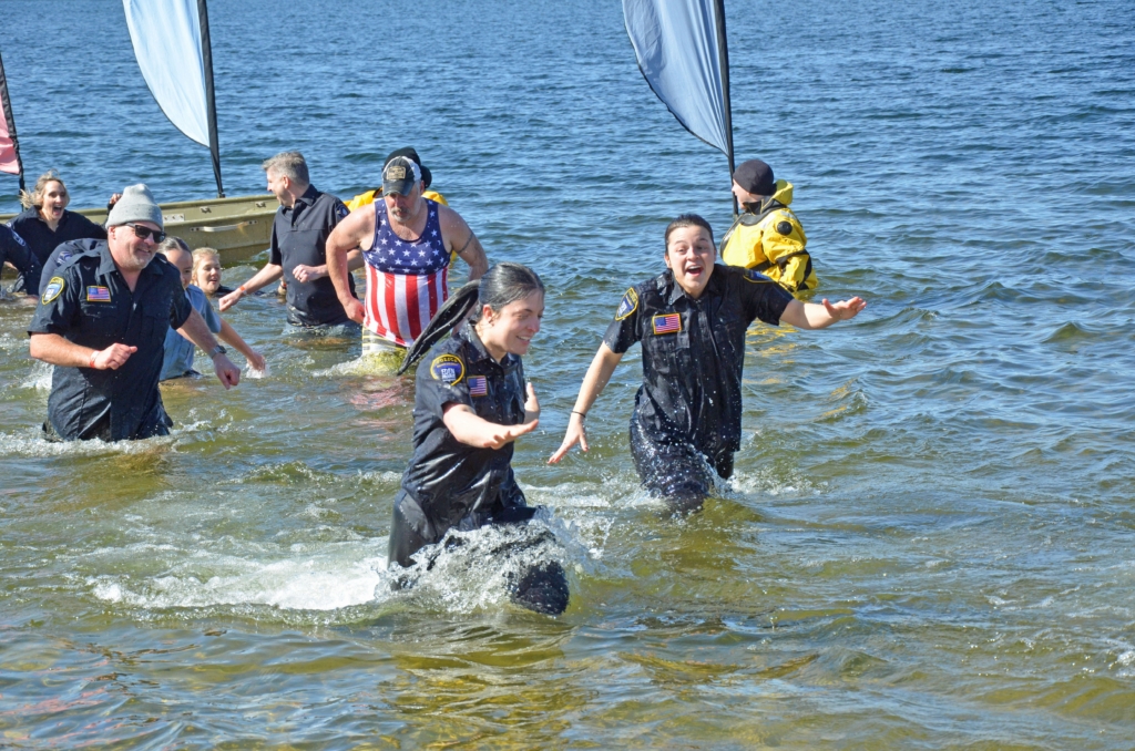 Eden Prairie Police Officer Emma Wax, left in foreground, and Officer Allison Biermaier rushed to the shore Saturday after diving into the cold waters of Lake Riley. Following them was Officer Carter Staff, left, wearing a stocking cap. Photo by Jim Bayer