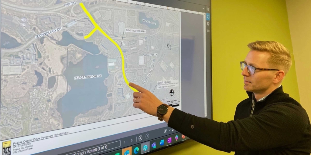 Assistant City Engineer Adam Gadbois points out the area of Prairie Center Drive scheduled for pavement rehabilitation this summer. Lane closures are expected to be part of the two-month street project. Photo by Mark Weber