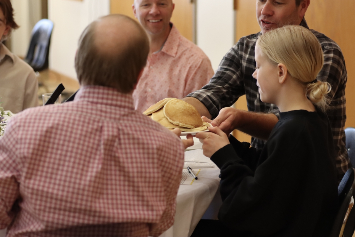 Curt Bakken and Tess Bakken share pancakes while Jason McBeth looks on during the meal at Prairie Lutheran Church's April 21 Brunch Church. Photo by Jon Quigley