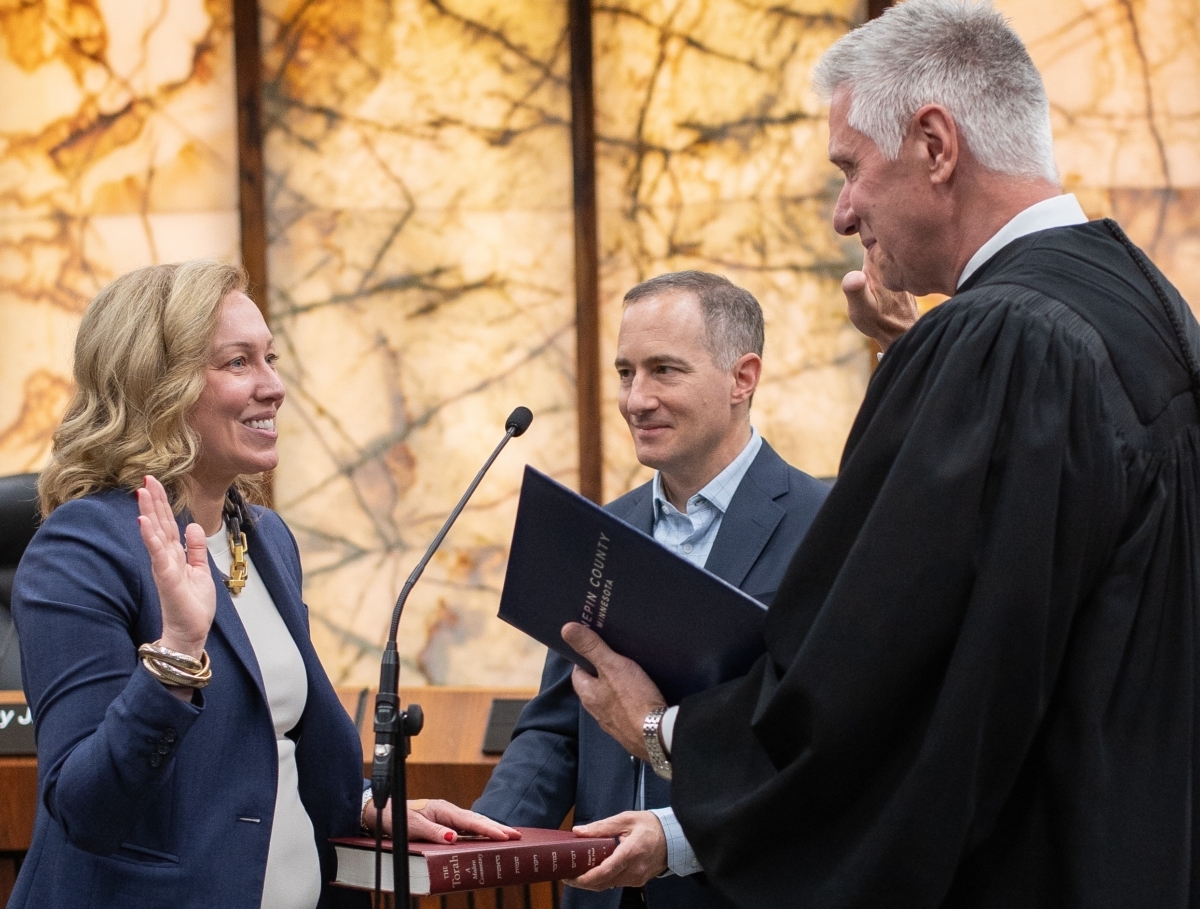 Heather Edelson is sworn in as District 6 Hennepin County commissioner by Mark Kappelhoff, assistant chief judge for Hennepin County District Court, as her husband, Brett, watches. Source: Hennepin County
