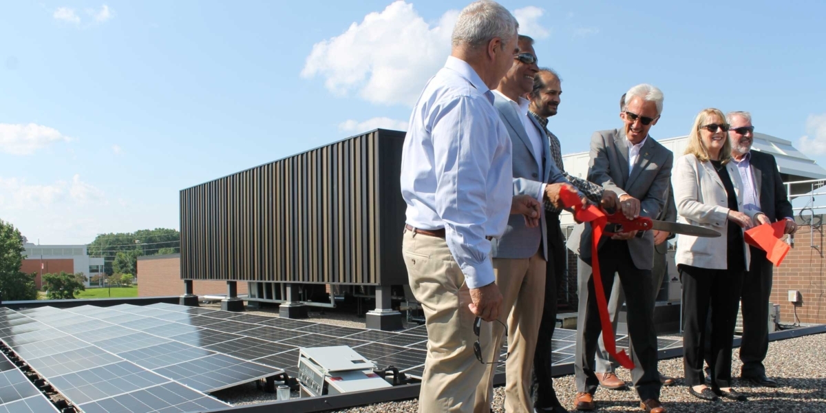 With solar panels and equipment behind them, officials cut a ribbon on the roof of the Eden Prairie Community Center on July 16 to celebrate the start of a new solar garden’s operation. From left are state Sen. Steve Cwodzinski, Eden Prairie Council Member PG Narayanan, Cooperative Energy Futures General Manager Timothy DenHerder-Thomas, Mayor Ron Case, Minnesota Department of Commerce Assistant Commissioner Pete Wyckoff (hidden behind Case), and Council Members Lisa Toomey and Mark Freiberg. Photos by Mark Weber