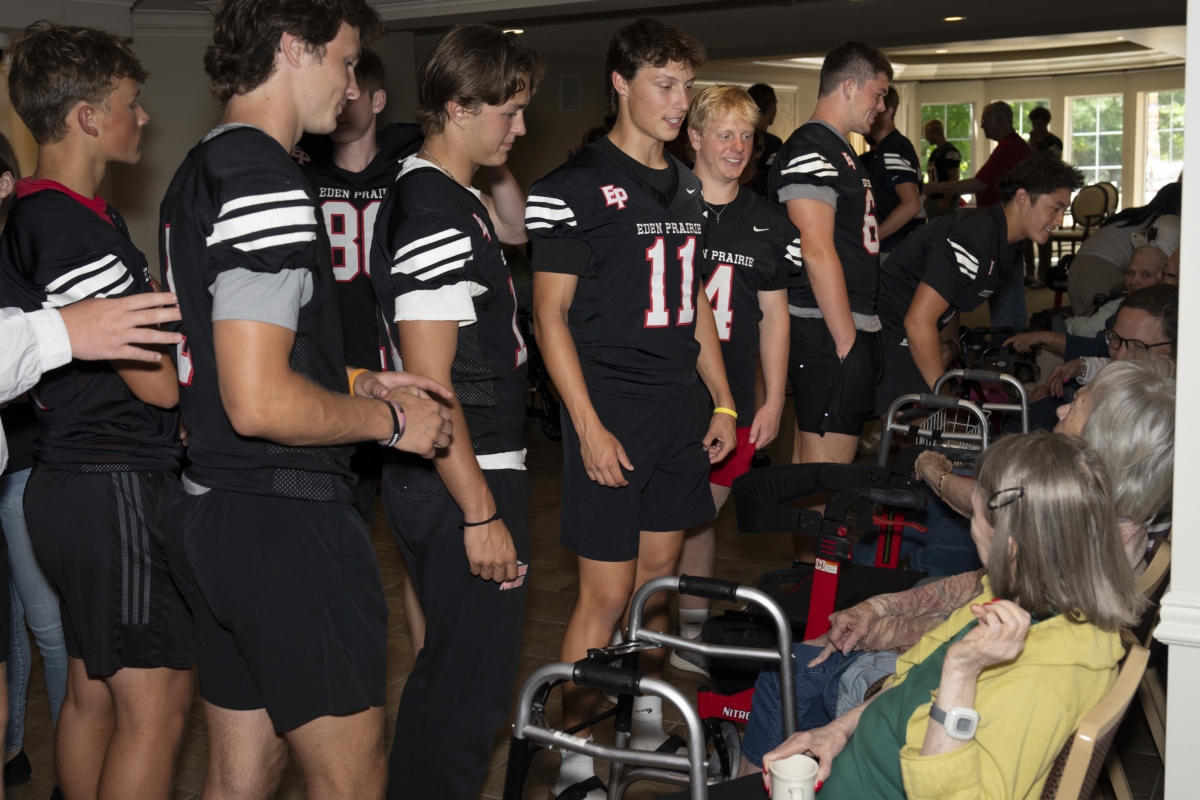 Members of the Eden Prairie Eagles football team paid their annual visit to The Waters senior living facility this month to engage staff and residents in conversation and friendly competition. Photo by Rick Olson