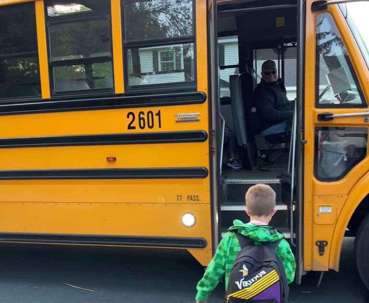 Logan Peters, a second-grader at Eagle Heights Spanish Immersion School, boards bus 2601 on the first day of school. His grandmother, Jackie Peters, captured this moment, highlighting the bus driver's welcoming smile.