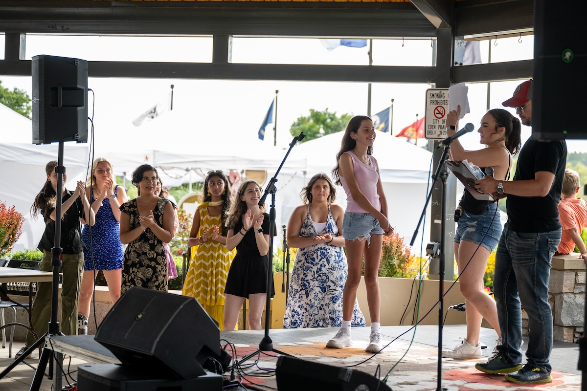 Miriam Gilbertson, left, is named the first-place winner by Lainey Donoghue, center, and Ryan Affolter, right, during the Eden Prairie Sings! competition on Aug. 17. The other contestants stand to Gilbertson's left. Photo by Jeremy Peyer