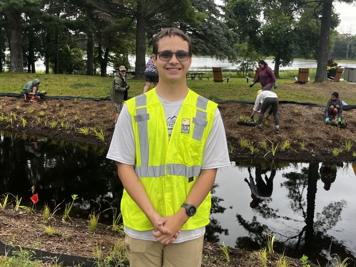 Maxwell Amundsen in front of the rain garden. Photo courtesy of the Amundsen family