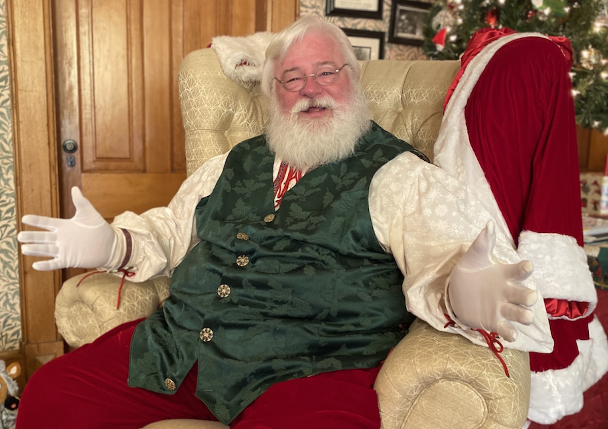John Hall, dressed as Santa, sits in the festive parlor of the Cummins-Phipps-Grill House in Eden Prairie on Saturday, Nov. 30, during a break from greeting children at the North Pole Experience. Photo by Stuart Sudak