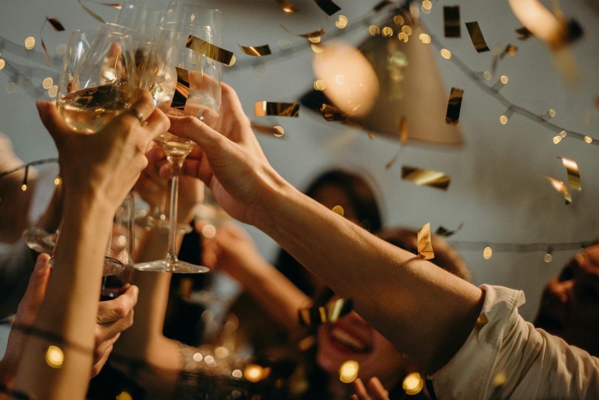 People toasting with champagne glasses, surrounded by confetti