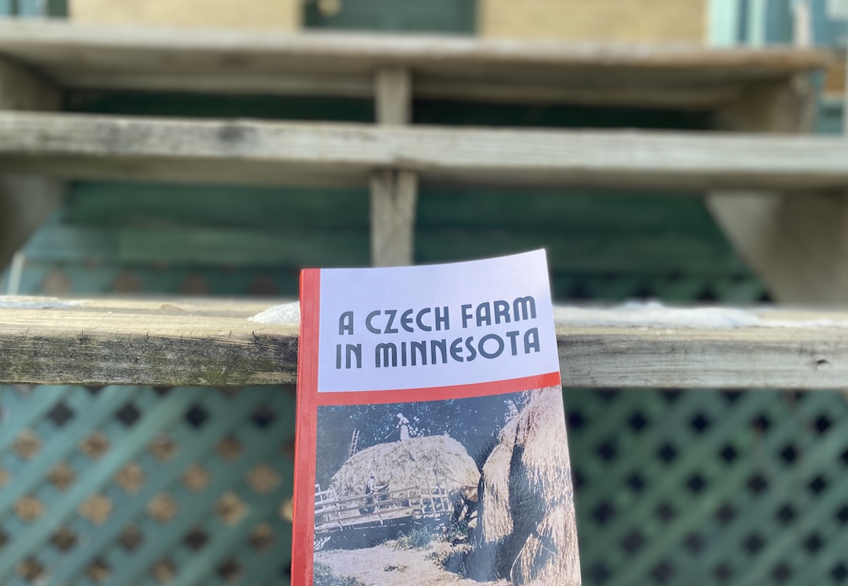 The cover of ‘A Czech Farm in Minnesota,’ a historical memoir by Janet Holasek Worrall, rests on the steps of the old Holasek farmhouse, now located at True Friends Camp Eden Wood. Worrall grew up in the home when it stood east of where Life Time Crosstown now sits. The book, published in December, traces her family’s journey from Bohemia to Minnesota and life on their Eden Prairie farm from the 1920s to the 1960s, exploring immigration, agriculture, and changing landscapes.