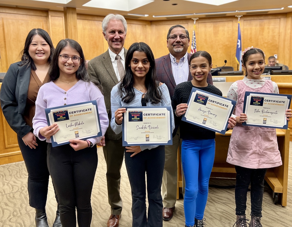 (From left) 2025 Words in Action Contest winners Leisha Mekala, Sonakshi Dwivedi, Amaya Demery, and Itisha Budamagunta. In the back row are Paja Xiong, city staff liaison for the Human Rights and Diversity Commission; Mayor Ron Case; and Human Rights and Diversity Commission member Babar Khan. Photo courtesy of the City of Eden Prairie